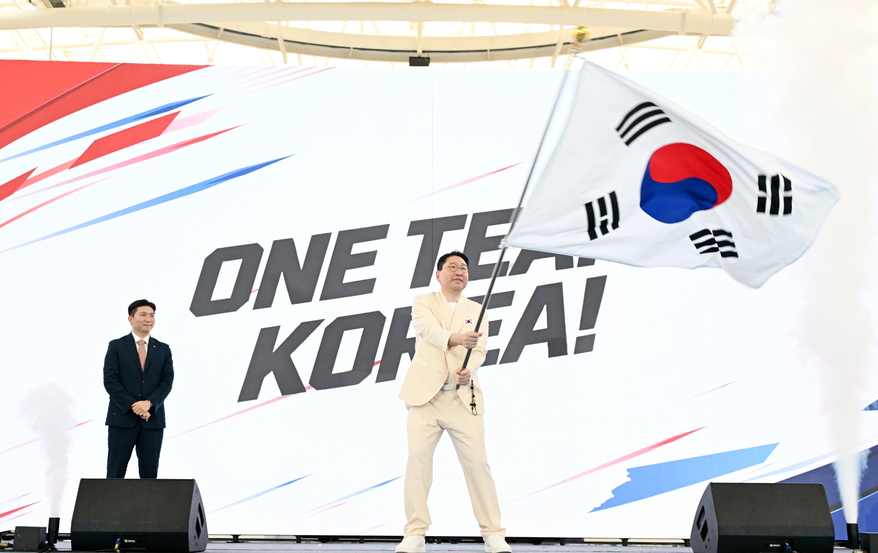 Lee Sang Hyun, le chef de la d&eacute;l&eacute;gation cor&eacute;enne aux Jeux asiatiques d&rsquo;Aichi-Nagoya, agite le drapeau cor&eacute;en lors la c&eacute;r&eacute;monie d&rsquo;encouragement organis&eacute;e &agrave; Jincheon, le 3 septembre 2026. &copy; Comit&eacute; olympique cor&eacute;en