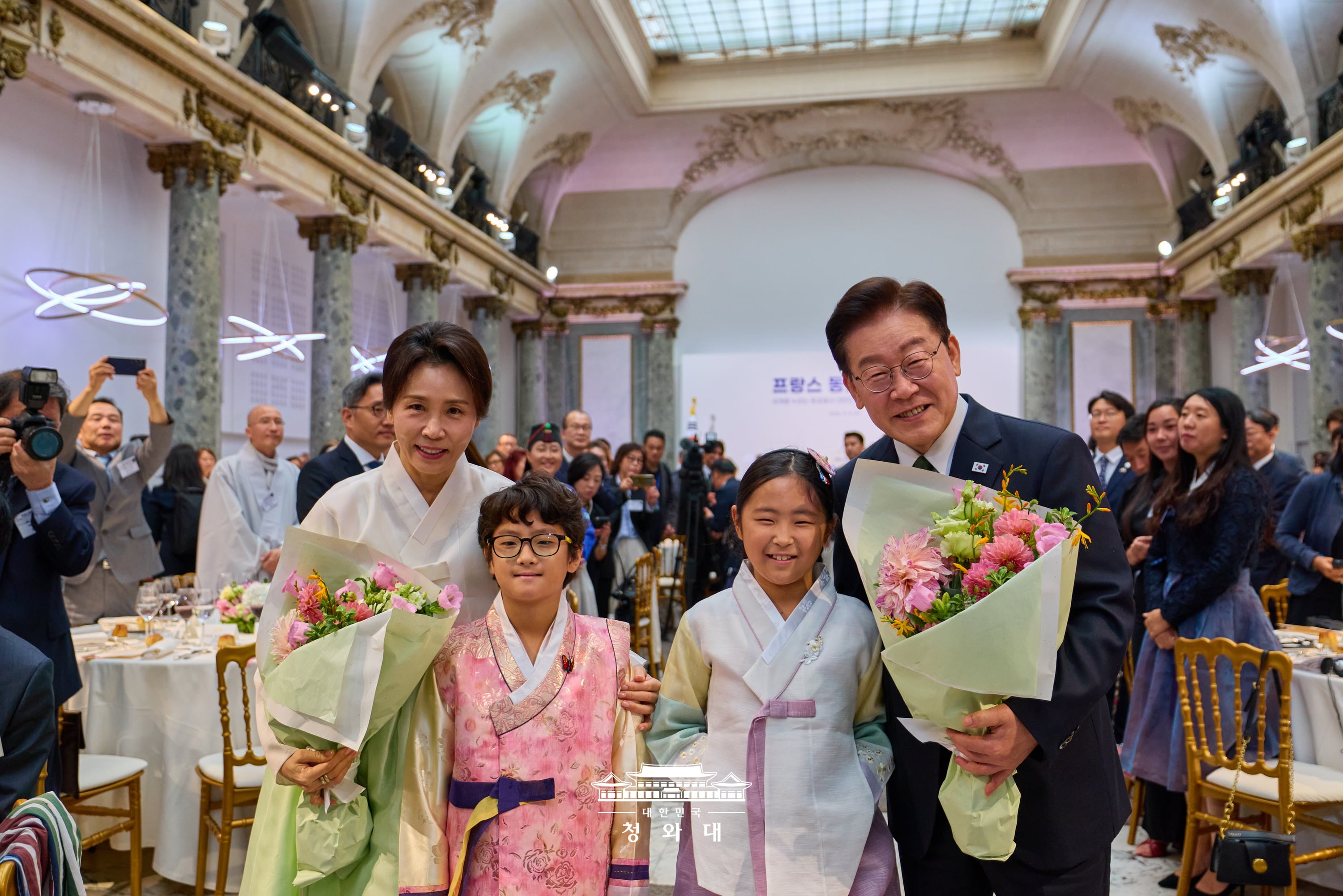 Le président Lee Jae Myung et la Première dame Kim Hea Kyung reçoivent un bouquet de fleurs par des enfants coréens lors d’un déjeuner avec la communauté coréenne résidant en France, à Paris, le 9 septembre 2026. © Cheong Wa Dae