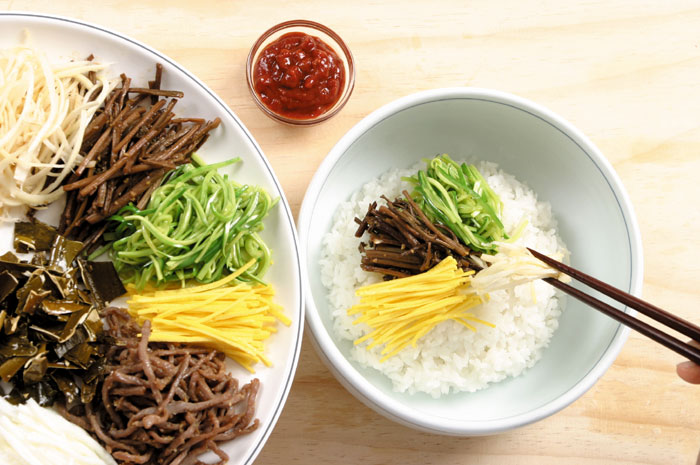 Put some cooked rice in a bowl and add the prepared meat and other ingredients along with some red pepper sauce. To make it taste great, the rice should be cooked properly, neither too hard nor too watery. You can add or subtract the fried red pepper paste, depending on your taste.