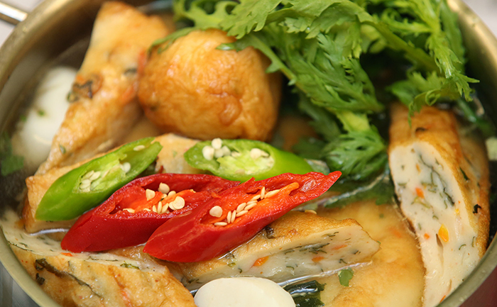Du piment et quelques feuilles de chrysanthème à couronne ajoutent de la couleur et de la saveur à l'eomuktang, une soupe qui contient des galettes de poisson de différentes formes.