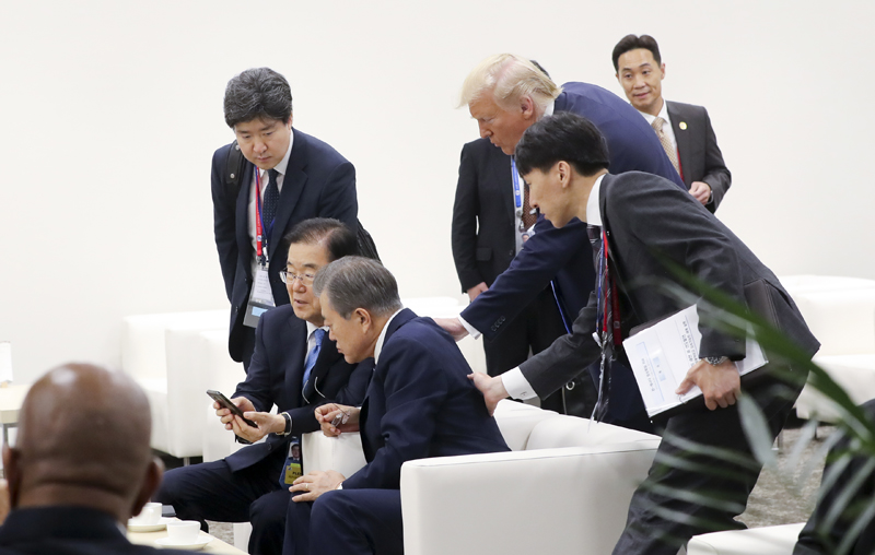 Le président américain Donald Trump s’approche à son homologue sud-coréen Moon Jae-in pour demander si Moon a vu son tweet concernant le dirigeant nord-coréen Kim Jong Un à Intex Osaka au Japon le 29 juin 2019. ⓒ Yonhap News