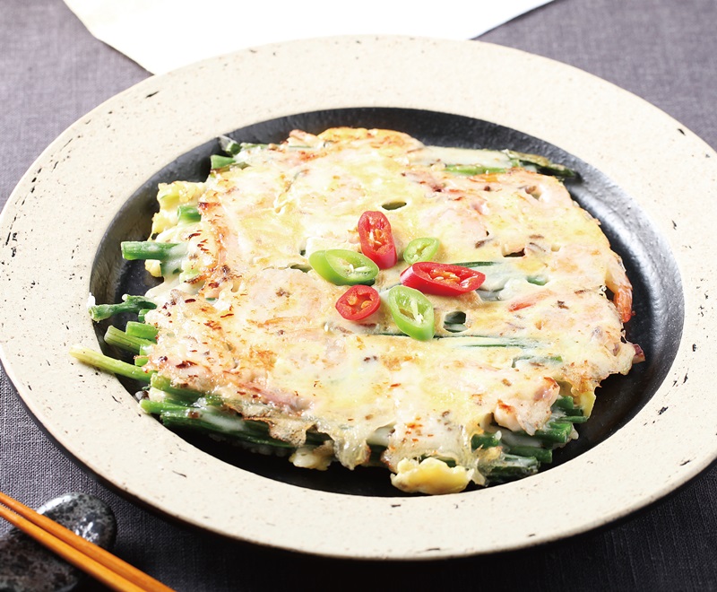 Le haemulpajeon, galette coréenne aux oignons verts et aux fruits de mer moulus. On met les vers de farine pour fabriquer la pâte.