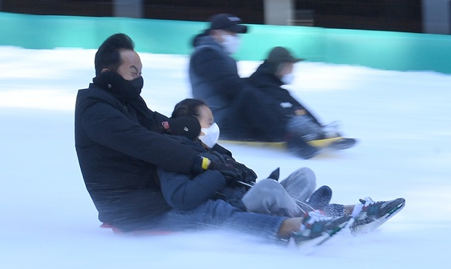 Père et fille sur une luge en hiver