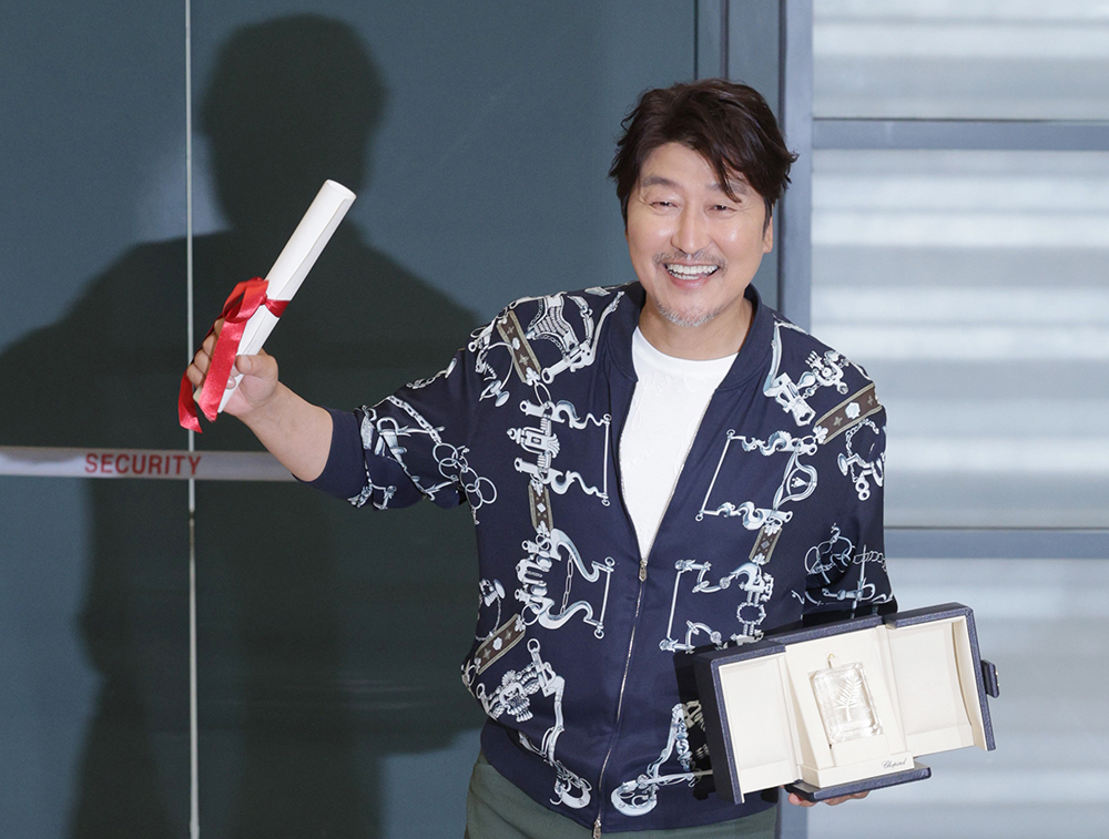 L'acteur Song Kang-ho, lauréat du prix d'interprétation masculine au 75e Festival de Cannes, pose avec son trophée après son arrivée à l'aéroport international d'Incheon, le 30 mai 2022.