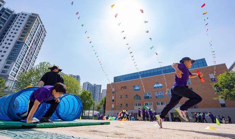Des élèves de l'école élémentaire Geumwha dans le district de Seodaemun à Séoul, le 2 mai, trois jours avant le Jour des enfants, courent sans masque dans une course de relais lors du festival sportif. © Yonhap News