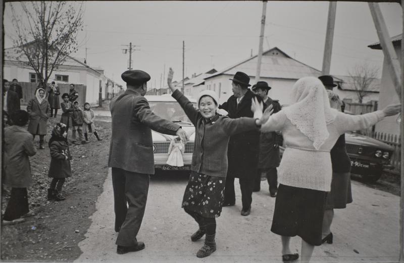 Sur cette photo du mariage d'Anatoliya An, prise en 1979 à Gulistan, dans la province ouzbèke de Siraryo Viloyati, on voit les mariés monter dans une voiture décorée de poupées et de rubans tandis que la famille et les proches du marié la guident et dansent. © Musée national folklorique de Corée