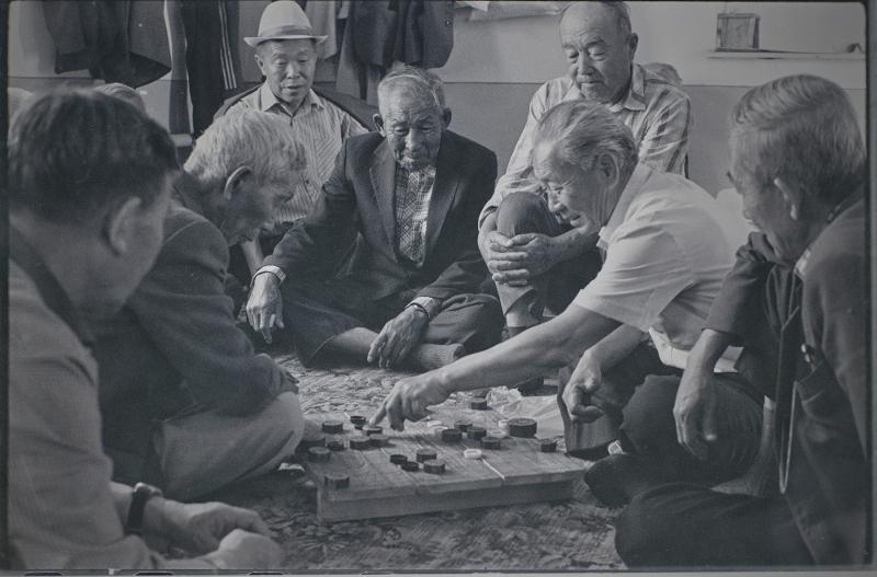 Des hommes âgés de Goryeoin jouent au janggi (jeu d'échecs coréen) à Sandmak, une maison de retraite du village de Kuilyuk à Tashkent, en Ouzbékistan, sur une photo prise en 1991. Contrairement au jeu de cartes coréen hwatu (Go-Stop), le janggi serait en voie de disparition parmi les Goryeoin, car ce sont surtout les personnes âgées qui y jouent. © Musée national folklorique de Corée