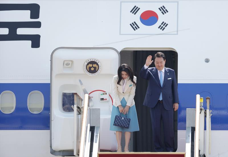 Le président Yoon Suk Yeol et la Première dame Kim Keon Hee saluent de la main à bord de l'avion présidentiel Code One à la base aérienne de Séoul, dans la banlieue sud de la capitale, à Seongnam, le 19 juin 2023. © Kim Sunjoo / Korea.net 