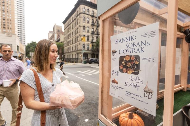 Une New-Yorkaise récupère sa dosirak (gamelle) lors de la campagne « Hansik : Soban & Dosirak », organisée par le ministère de la Culture et le conseil des arts créatifs coréen à Manhattan du 12 au 14 septembre 2022.