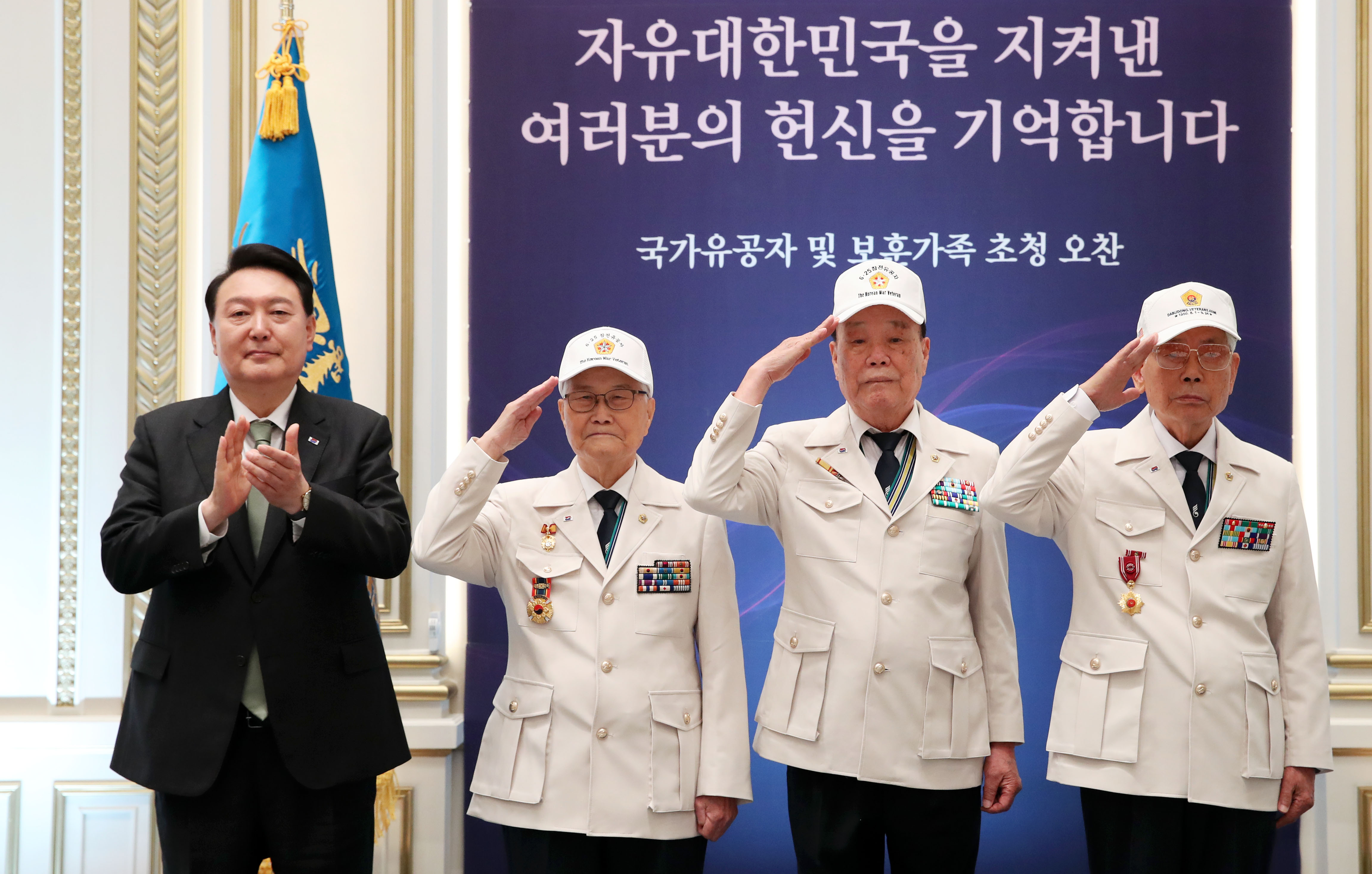Le président Yoon Suk Yeol applaudit aux côtés de trois membres de l'Association des vétérans de la guerre de Corée, à la maison d’hôtes Yeongbingwan de Cheong Wa Dae, le 14 juin 2023. Le ministère des Patriotes et des Anciens combattants a vu le jour sous l’administraton Yoon, qui a également augmenté les indemnités versées aux anciens combattants de 5,5 %.