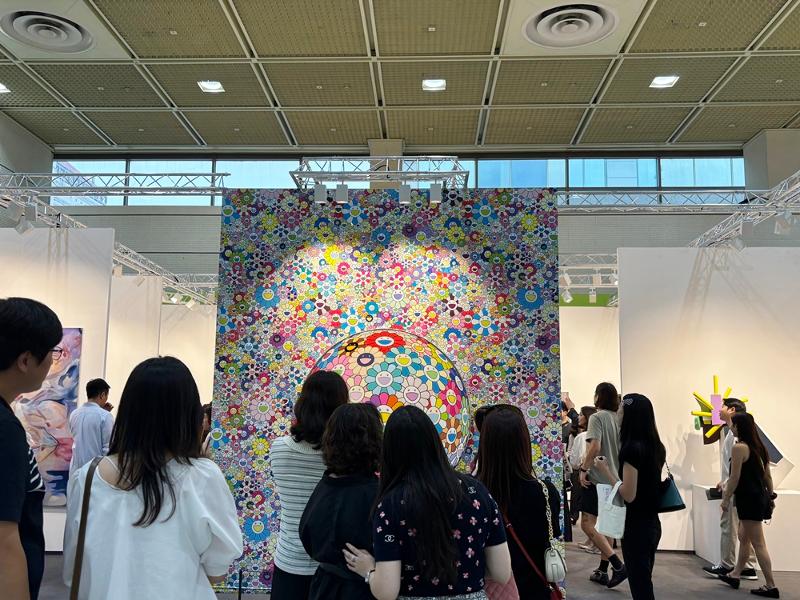 Un groupe de visiteurs admire l’œuvre de l’artiste japonais Takashi Murakami, Flowers with Smiley Faces, dans le stand de la galerie Perrotin. © Korea.net / Gil Kyuyoung