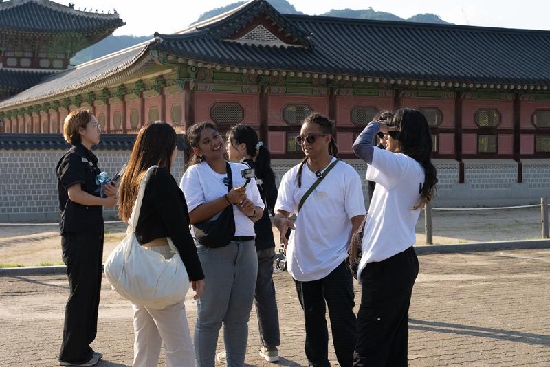 Un groupe de participants à la saison de 2 de de Star K-influencer Boot Camp discute au palais Gyeongbokgung, à Séoul, le 27 septembre 2024. © Ministère de la Culture, des Sports et du Tourisme
