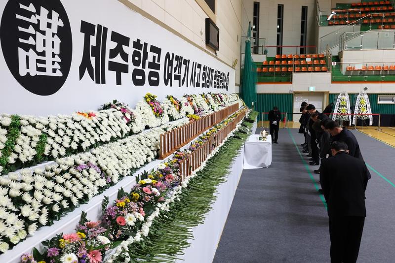 Des citoyens font une prière en silence après avoir déposé des fleurs sur un autel commémoratif du crash de l’avion Jeju Air, au Muan Sports Park, à Muan, dans le Jeolla du Sud, le 30 décembre 2024. © Agence de presse Yonhap