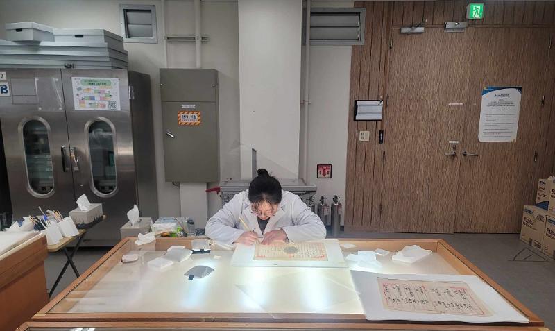 Une agente travaille à la restauration des archives de la révolte paysanne du Donghak, aux archives nationales de Corée à Seongnam, le 7 janvier 2025. © Yoo Yeon Gyeong / Korea.net