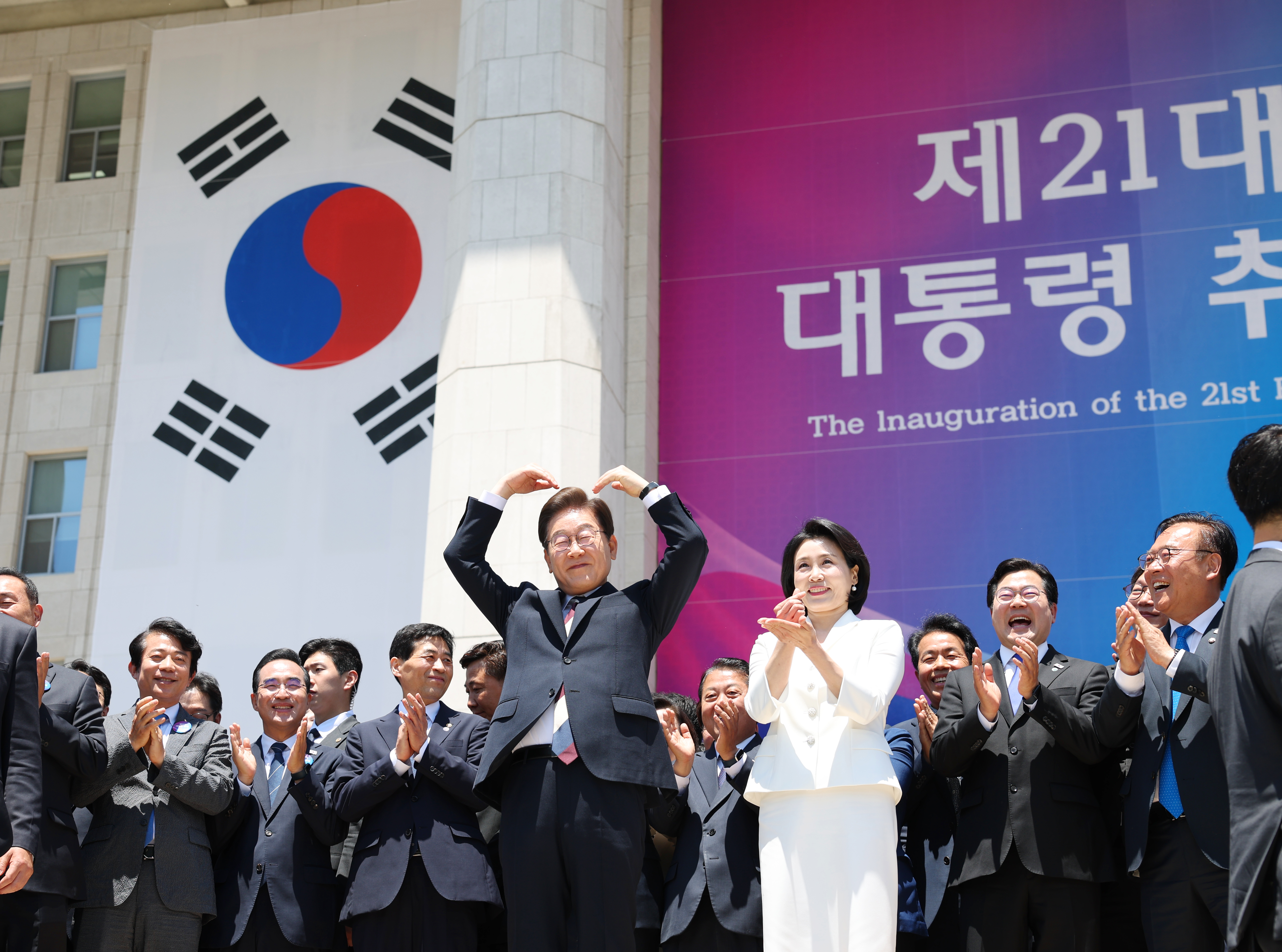 Lee Jae-myung fait un cœur avec ses bras aux côtés de son épouse devant ses partisans réunis devant l’Assemblée nationale, à Séoul, le 4 juin 2025. © Groupe de photographes du gouvernement