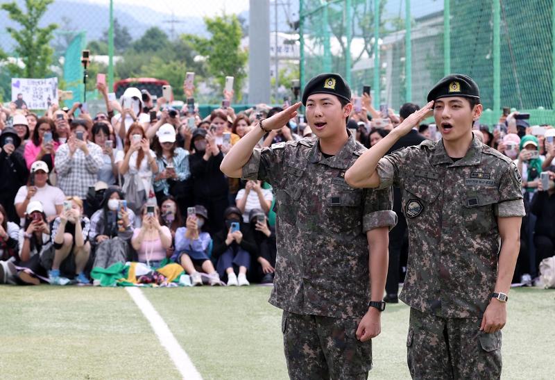 RM et V, membres de BTS, effectuent un salut militaire à des fans rassemblés dans un parc à Chunchon, dans la province du Gangwon, le 10 juin 2025. © Agence de presse Yonhap