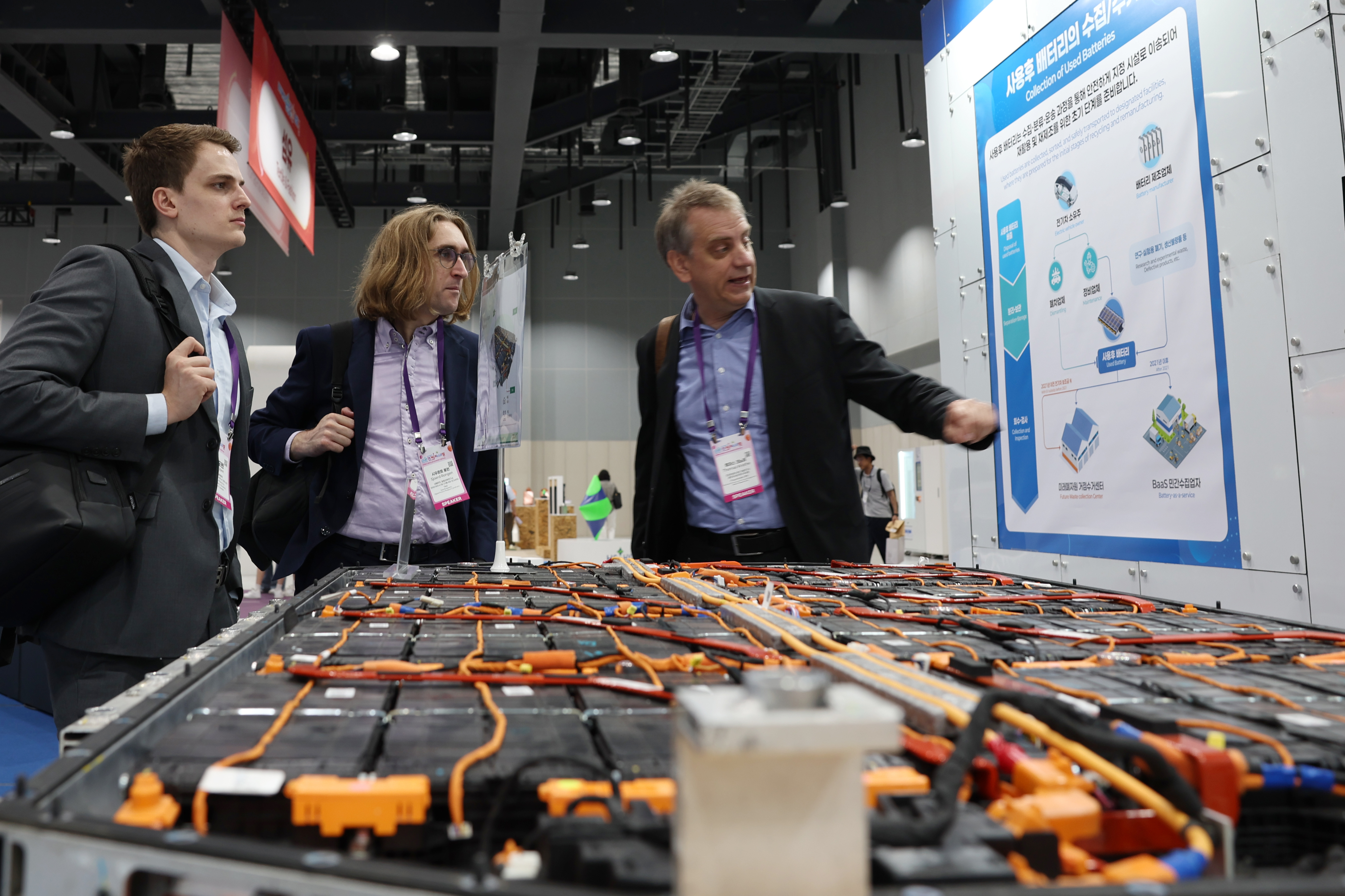 Un groupe de participants au 2025 Korea Circular Economy Festival observe un stand dédié au recyclage de batteries lors de cet événement organisé au centre des expositions Coex Magok, dans l’ouest de Séoul, le 2 juillet 2025.