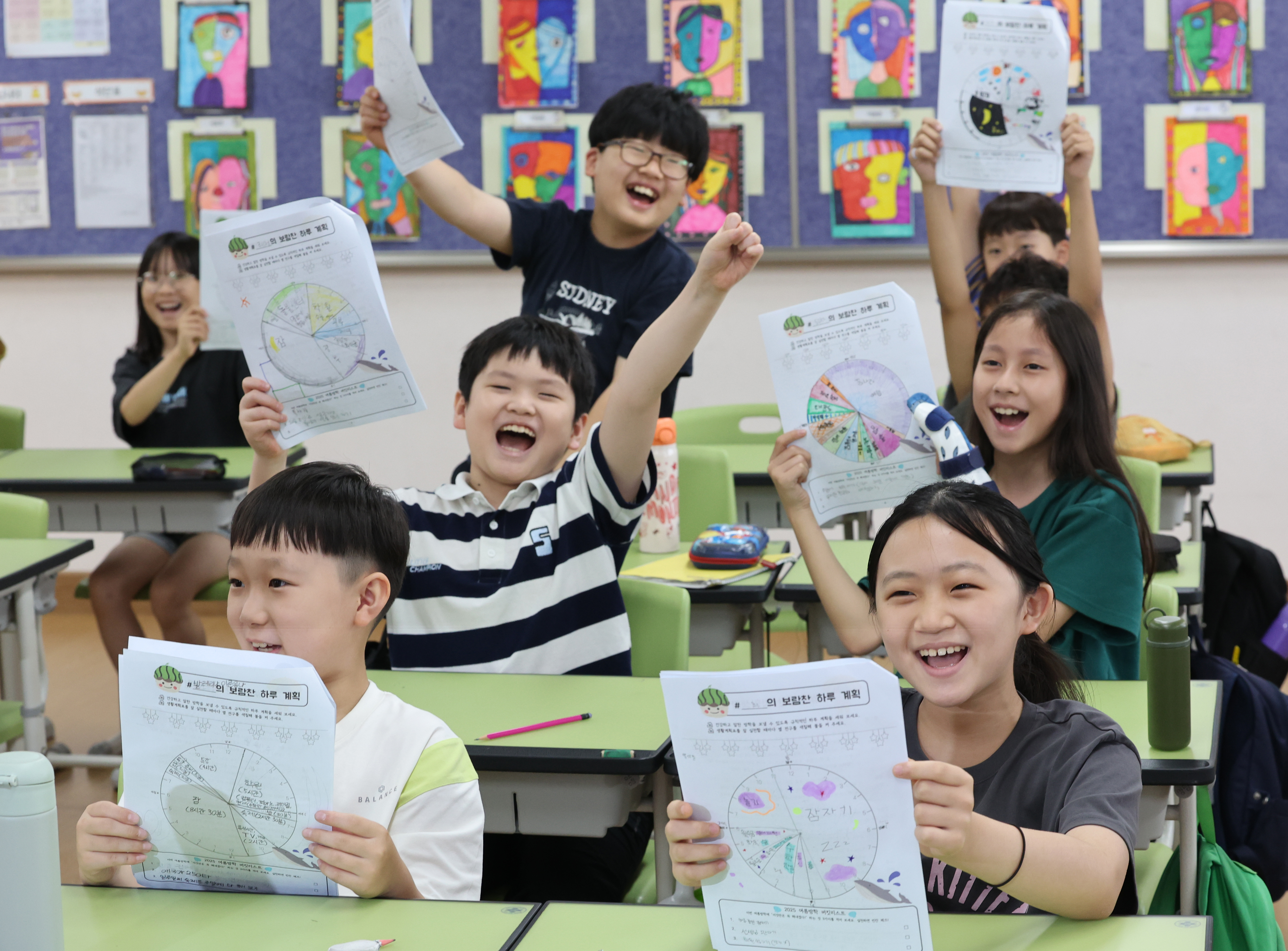Un groupe d’élèves de quatrième année (CM1 français) à l’école primaire Samil, dans l’arrondissement Dongjak de Séoul, brandissent une feuille sur laquelle ils ont écrit comment ils comptaient passer leurs vacances d’été, le 23 juillet 2025.