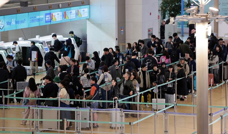 Des voyageurs font la queue devant un comptoir d’enregistrement du terminal 1 de l’aéroport d’Incheon, le 1er mai 2025. © Agence de presse Yonhap