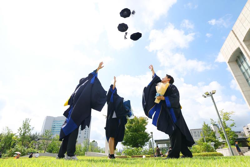 Trois jeunes diplômés de l’université Yonsei célèbrent la fin de leurs études, à Séoul, le 29 août 2025. © Bureau présidentiel