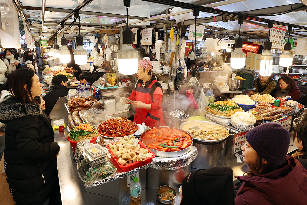 Des visiteurs découvrent la cuisine de rue abondante au marché de Gwangjang, à Séoul, le 10 décembre 2025. © Lee Jeong Woo / Korea.net