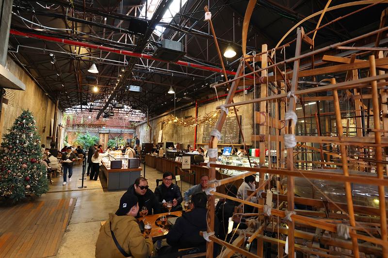 Des touristes se détendent dans un café aménagé dans un ancien bâtiment industriel, le 9 décembre 2025.