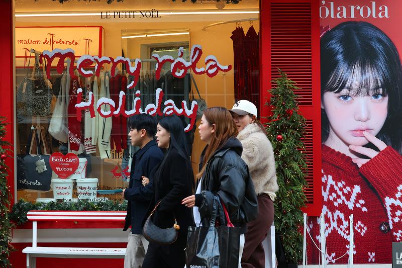 Un groupe de touristes passe devant un magasin de vêtements dans le quartier de Seongsu, à Séoul, le 9 décembre 2025. © Lee Jeong Woo / Korea.net