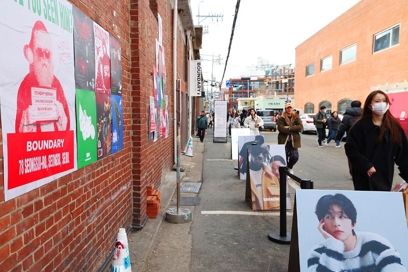 Des affiches de mode se détachent sur fond de vieux bâtiments en briques dans le quartier de Seongsudong, à Séoul, le 9 décembre 2025. © Lee Jeong Woo / Korea.net