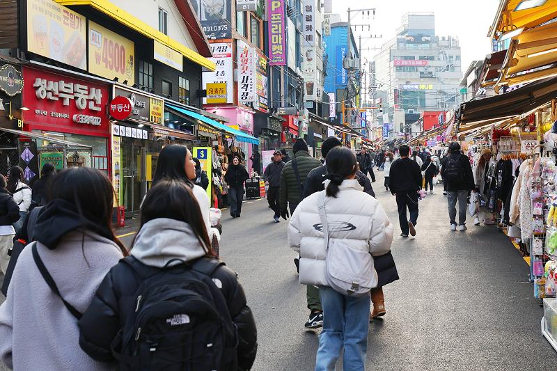 Des touristes circulent dans le quartier de Hongdae, à Séoul, le 10 décembre 2025. © Lee Jeong Woo / Korea.net