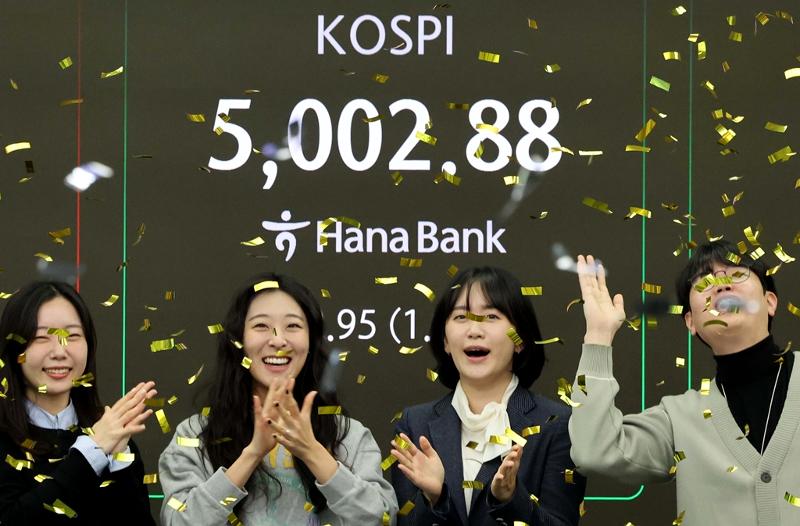 Des traders de la Hana Bank applaudissent alors que l&rsquo;indice boursier KOSPI a d&eacute;pass&eacute; la barre des 5 000 points, &agrave; S&eacute;oul le 22 janvier 2026. &copy; Agence de presse Yonhap